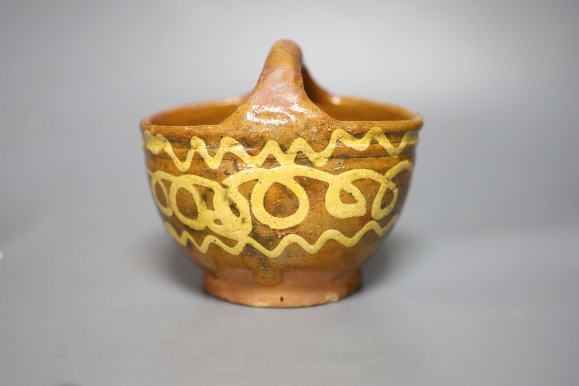 An early 19th century slipware basket, Donyatt Somerset and a similar slipware dish, diameter 18cm